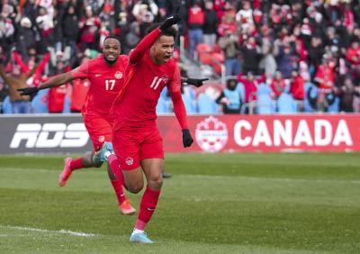 Team Canada’s Tajon Buchanan (11) celebrates his goal with teammate Cyle Larin after scoring against Jamaica during first half men's World Cup qualifier soccer action in Toronto on March 27, 2022. (THE CANADIAN PRESS/Nathan Denette)