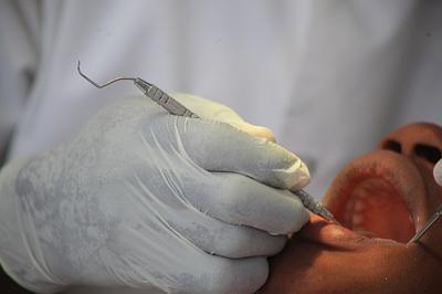 A dentist checks a patient’s teeth. A dentist checks a patient’s teeth.