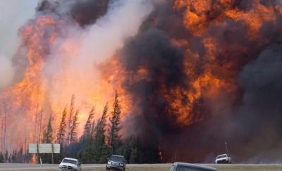 A giant fireball is seen as a wildfire rips through the forest 16 kilometres south of Fort McMurray, Alberta on Highway 63 on May 7, 2016. (THE CANADIAN PRESS/Jonathan Hayward)