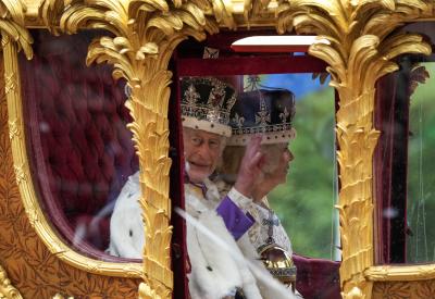 King Charles III waves from the carriage beside Queen Camilla during the royal procession following the King's coronation, in London on May 6, 2023. (THE CANADIAN PRESS/Nathan Denette)