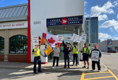Canada Post workers picket outside a Canada Post outlet. (Photo via CUPW Local 602’s Facebook page.)