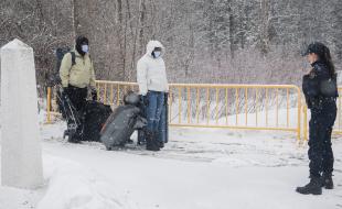 An RCMP officer stops people as they enter Canada via Roxham Road on the Canada-U.S. border in Hemmingford, Quebec, March 25, 2023. (THE CANADIAN PRESS/Graham Hughes)