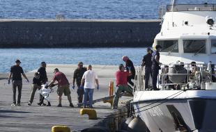 A child escorted by coast guard officers disembarks with other migrants from a vessel after a rescue operation, at the port of Mytilene, on the northeastern Aegean Sea island of Lesbos, Greece, on August 28, 2023. (AP Photo/Panagiotis Balaskas) 