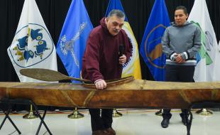 Elder Darrel Nasogaluak (left) and Natan Obed examine a traditional Inuvialuit kayak returned from the Vatican. (Image: Canadian Press/Sean Kilpatrick.)